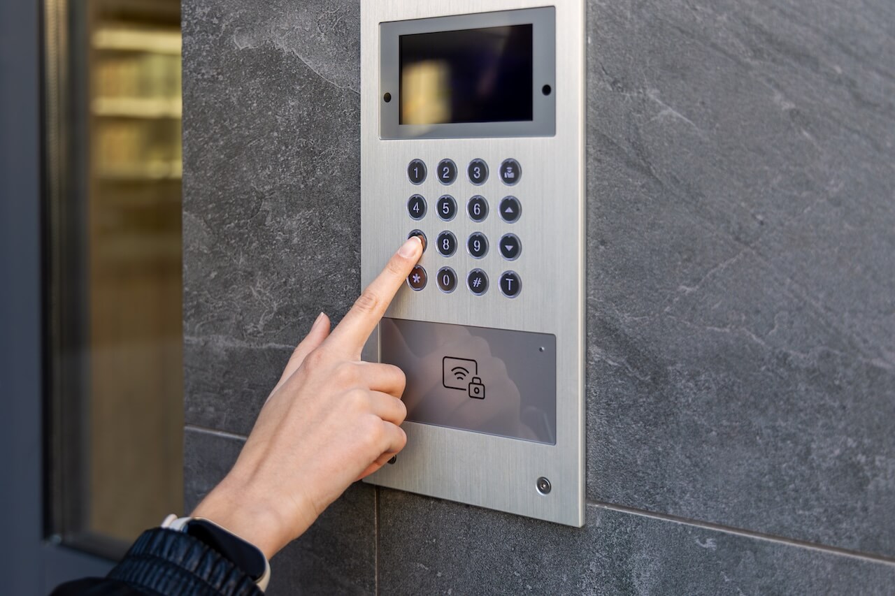 Close-up of a hand entering a code on a modern video intercom