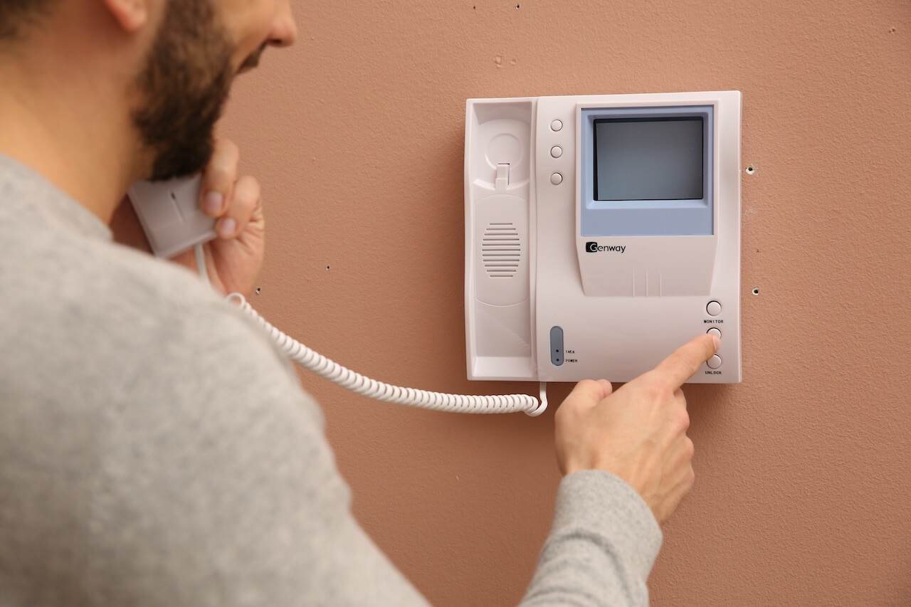 Man answering intercom call at home, closeup