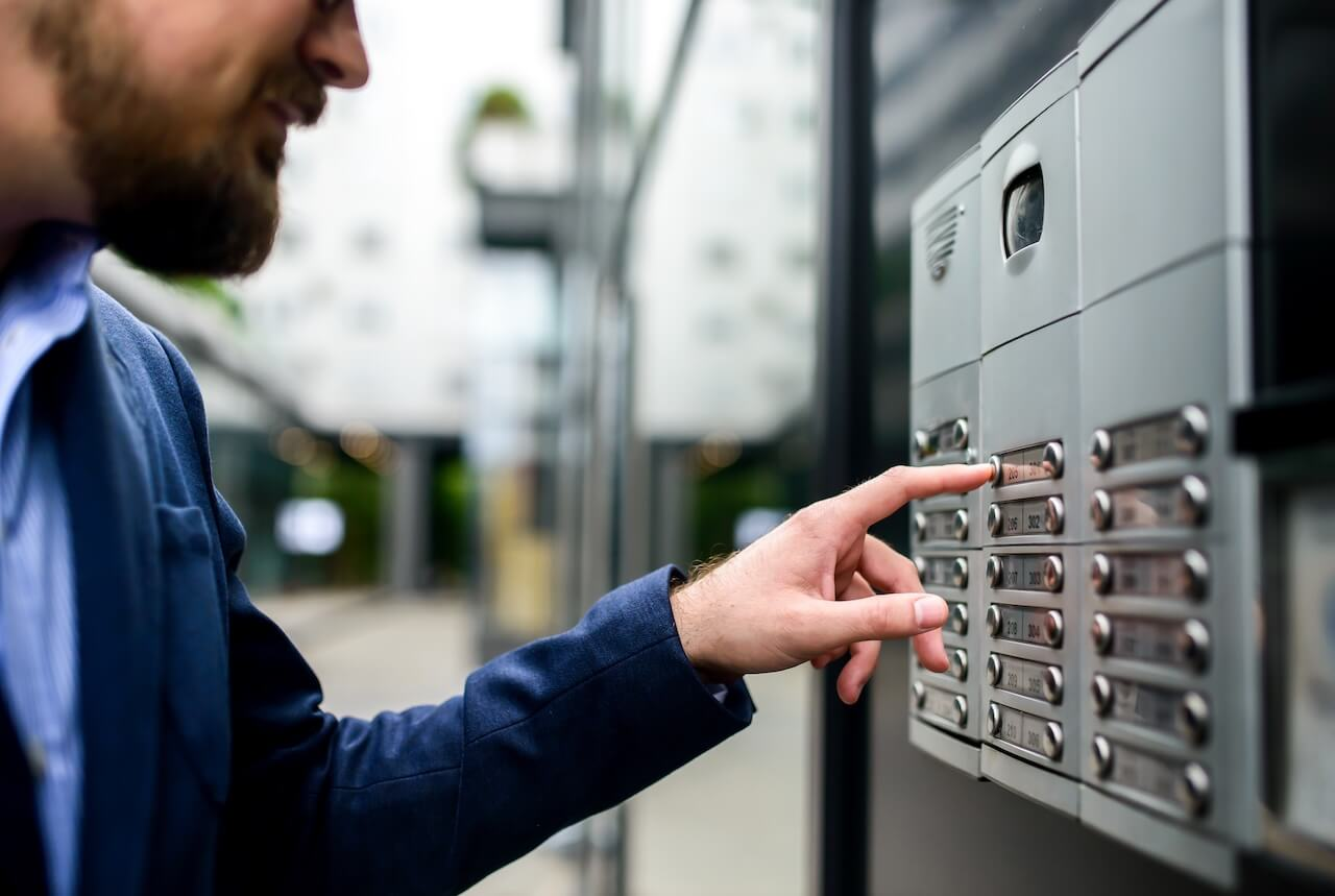 Man pushing the button and talking on the intercom