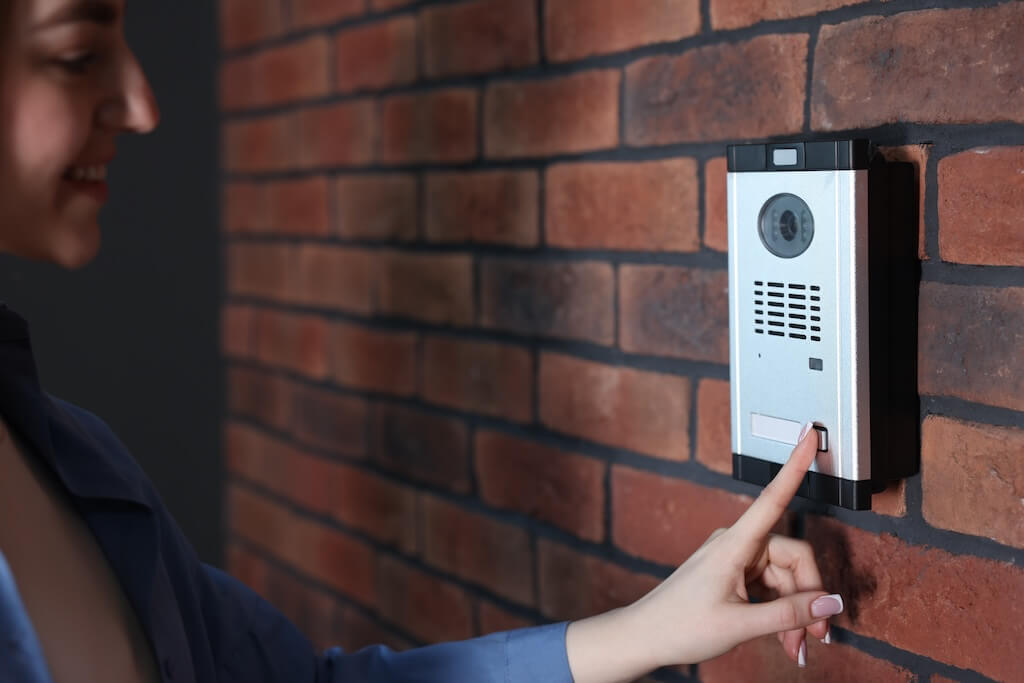 Woman pressing button on intercom panel