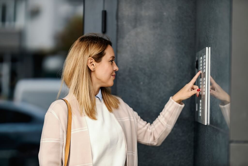 woman ringing on intercom on a building