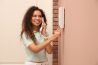 Young woman answering intercom call indoors