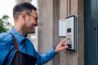 smiling man pressing bottoms on the intercom
