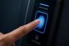 Finger pressing biometric fingerprint scanner on door lock