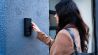 woman using the intercom to enter the building